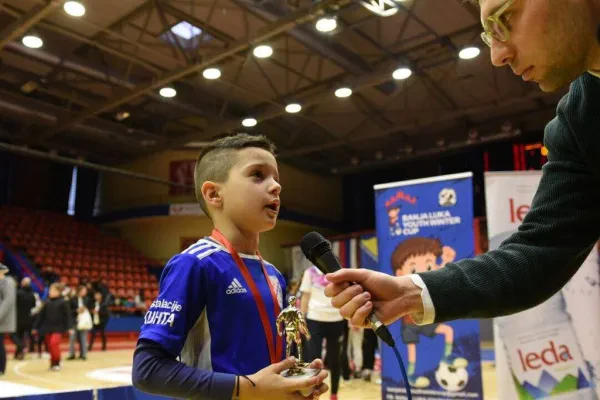 Banja Luka Youth Winter Cup football tournament, young player giving an interview while holding a trophy.