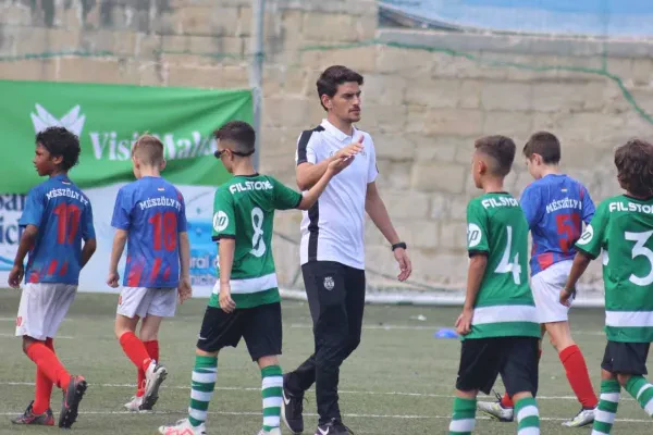 Kids in football gear and coach on the field at U13 KHS Cup tournament